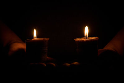 Close-up of lit tea light candles in darkroom