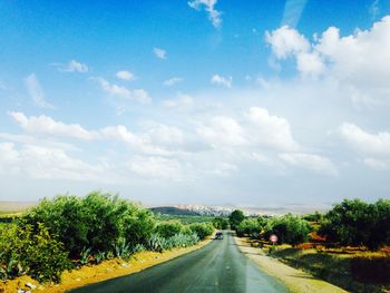 Country road against cloudy sky