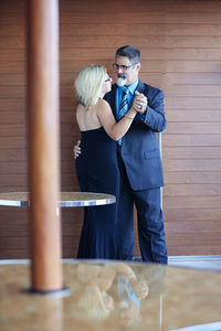 Businessman with woman standing against wall