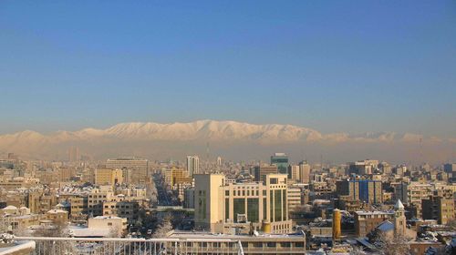 Aerial view of buildings in city against clear sky