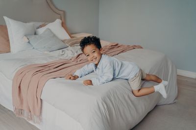 Rear view of boy lying on bed