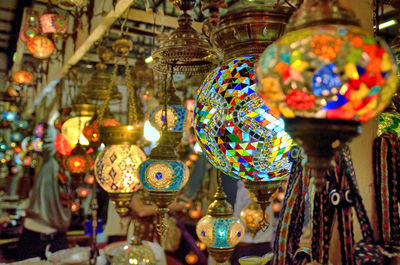 Close-up of illuminated lanterns hanging in store for sale in market