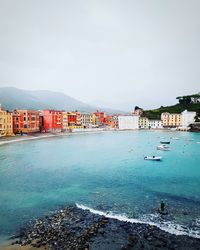 Scenic view of sea by buildings against clear sky