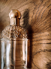 Golden bottle parfume with wooden background 