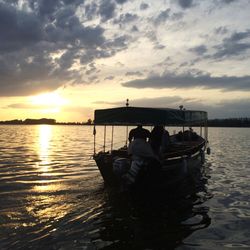 Scenic view of sea against cloudy sky during sunset