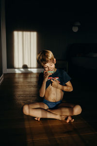 Cute girl sitting on hardwood floor at home