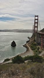 Suspension bridge over sea against sky