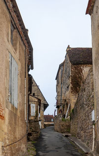 Narrow alley amidst old buildings against sky