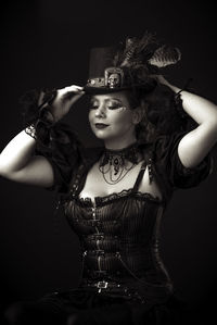 Woman in costume against black background