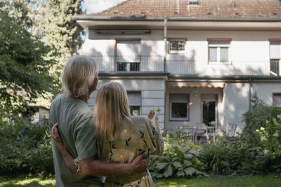 Couple standing together looking at house