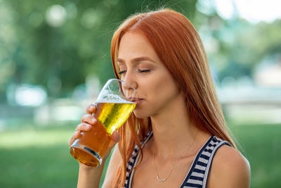 Portrait of woman drinking beer glass