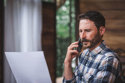 Midsection of man using mobile phone