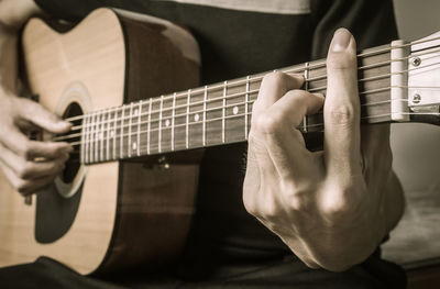 Midsection of man playing guitar