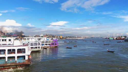 Boats in sea against buildings in city