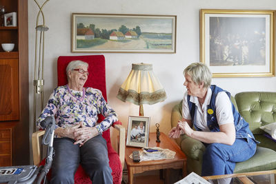 Senior woman talking with nurse in care home