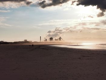 The sun setting over redcar beach with old steel works in background