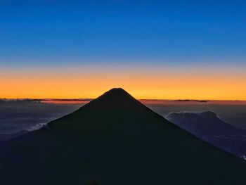 Scenic view of snowcapped mountains against clear sky during sunset