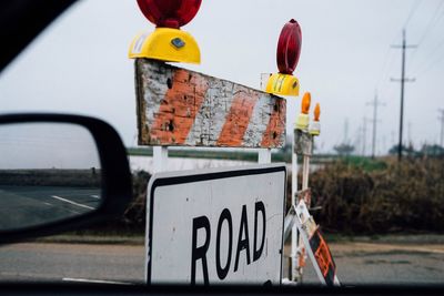 Close-up of road sign against sky