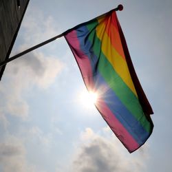 Low angle view of rainbow flag against sky