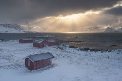 Snow covered land and sea against sky