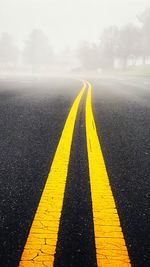 Surface level of yellow road by fog