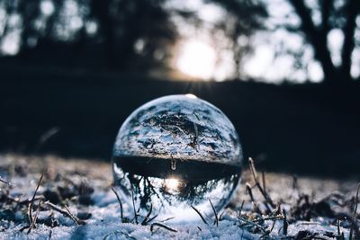 Close-up of crystal ball on field during winter