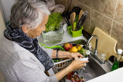 Midsection of woman having food at home