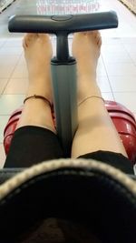 Low section of woman sitting on tiled floor