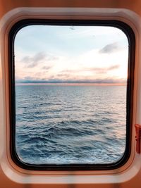 Scenic view of sea against sky seen through window