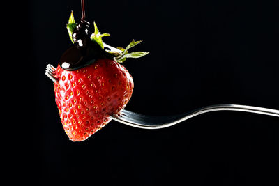 Close-up of strawberry over black background