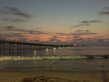 Bridge over sea against sky during sunset