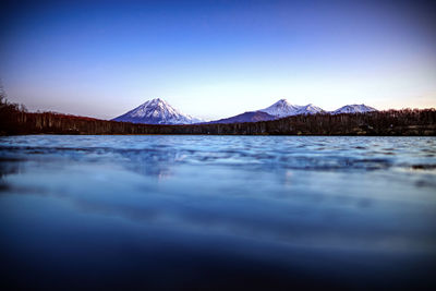 Scenic view of snowcapped mountains against clear blue sky