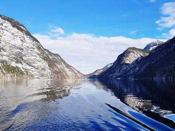 Scenic view of lake and mountains against blue sky