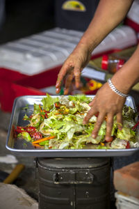 Man tossing salad in tray