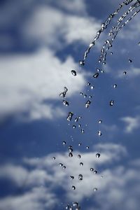 Low angle view of water drops against sky