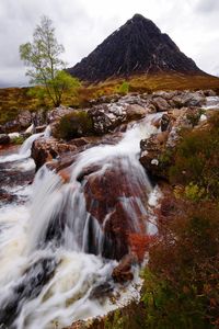 Scenic view of waterfall against sky