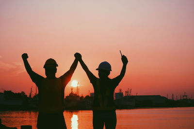 Silhouette people standing against sky during sunset