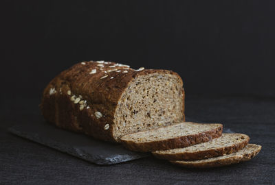 One rye seeded sliced bread on a black background.