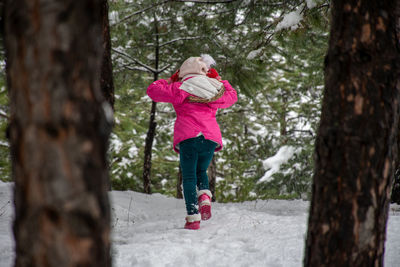 Full length of woman on tree trunk during winter