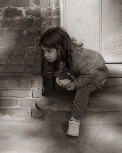 Girl sitting against wall