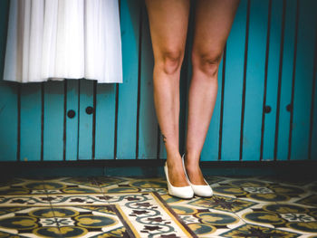 Low section of woman standing on bed