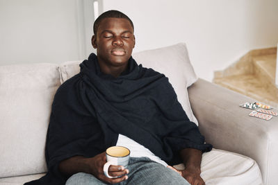 Mid adult man sitting on sofa at home