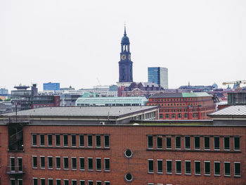 Buildings in city against clear sky