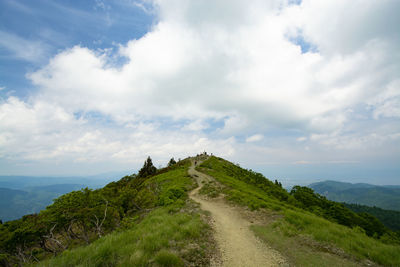 Road leading towards mountain against sky