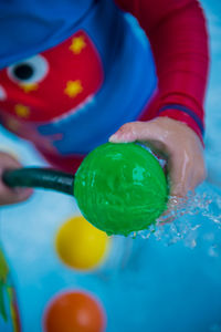 Close-up of hand holding multi colored balloons