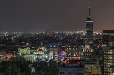 Aerial view of torre latinoamericana and palacio de bellas artes in city at night against clear sky