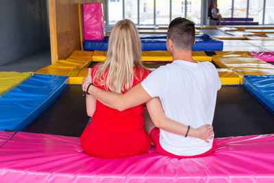 Rear view of people sitting on floor