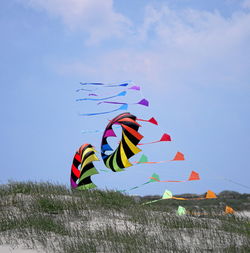 Low angle view of kite flying over field against sky