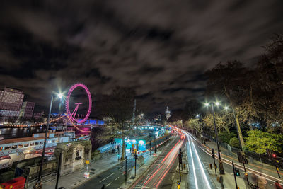 Light trails on road against sky at night