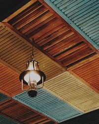 Low angle view of lantern hanging on wooden roof